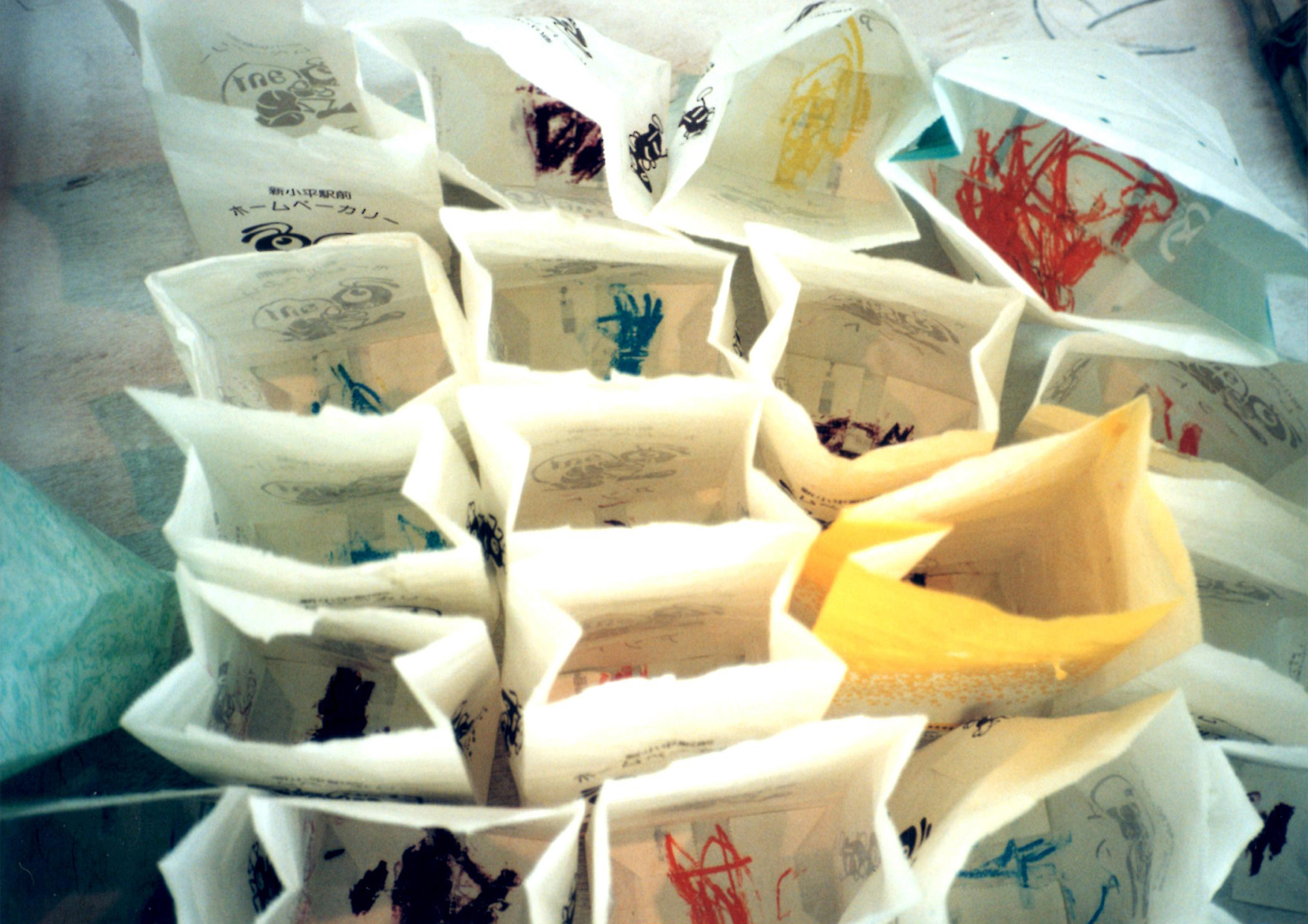 「わたしがかつて絵を描くために必要としていた装置」解体式（部分） 制作年：1997年10月／展示場所：武蔵野美術大学課外センター展示室／素材：紙袋、クレヨン、綿ゴム